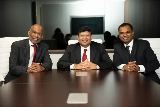 Somireddy Law Group attorneys Keith Blair, Santosh Somireddy, and Vijay Yellareddigari in a conference room.