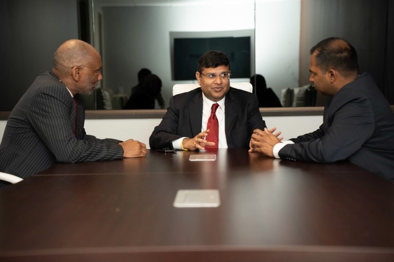 Somireddy Law Group attorneys Keith Blair, Santosh Somireddy, and Vijay Yellareddigari in a conference room meeting.